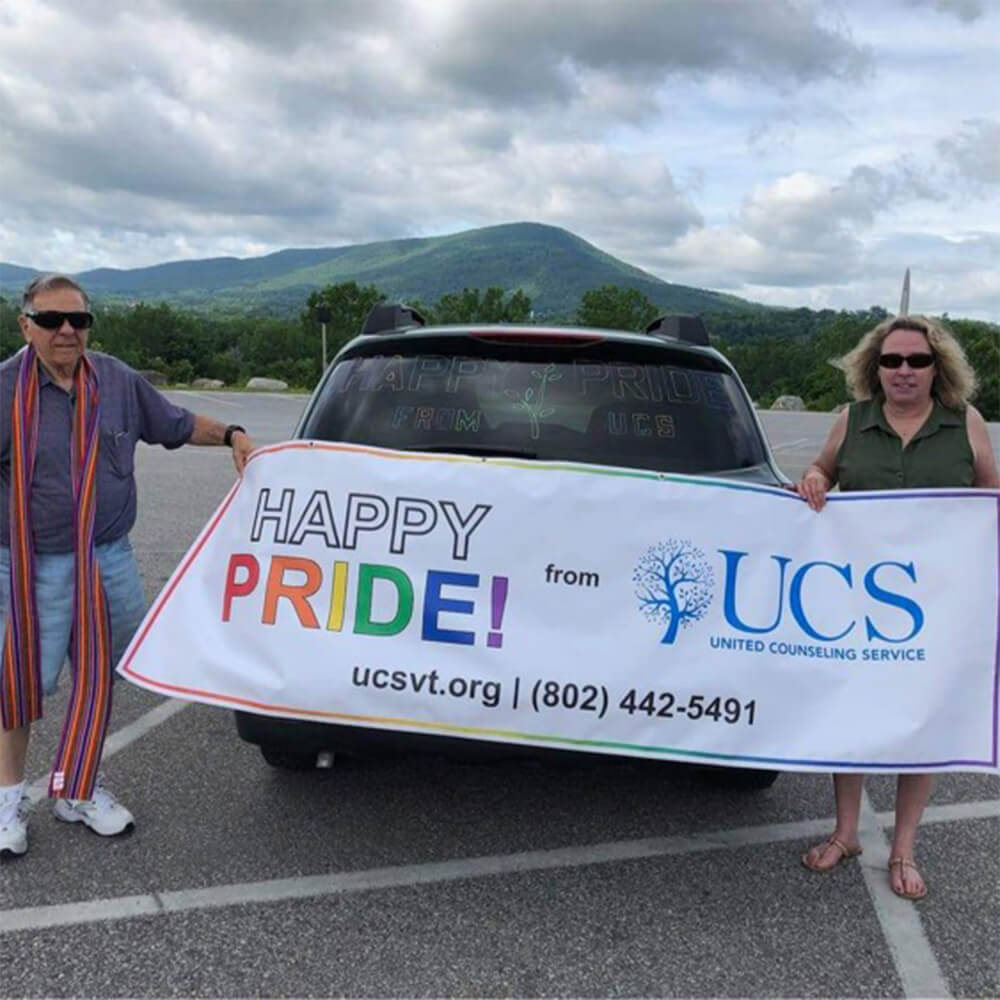Two people hold a banner that sayd Happy Pride from UCS!
